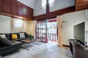 a living room with a couch and a tv at Bungalow Phuket in Kamala Beach