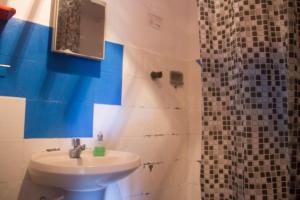 y baño con lavabo y ducha. en Macondo Hostel, en Morro de São Paulo