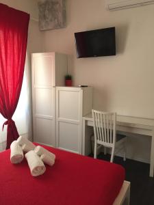 um quarto com uma cama vermelha, uma secretária e uma cortina vermelha. em De Guestibus em Roma