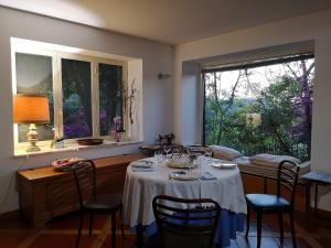 a dining room with a table with chairs and a window at La Tinaia Country House in Magomadas