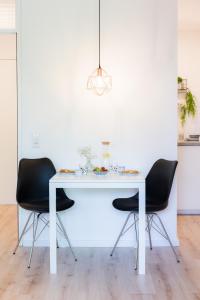 a white table with black chairs in a room at Holiday Appartement »Achalm« mit Sonnenterrasse in Reutlingen