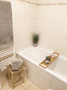 La salle de bains est pourvue d'une baignoire, d'une chaise et d'une plante. dans l'établissement Holiday Appartement »Achalm« mit Sonnenterrasse, à Reutlingen