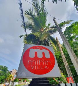 una señal para un restaurante frente a una palmera en Mihin Villa, en Bentota