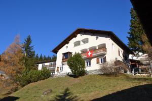 a large white building on a hill with trees at Bisang R in Arosa