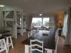 a dining room and living room with a table and chairs at Dolphin Place in Port Shepstone