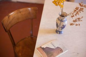 un tavolo con un vaso con fiori e un libro di All'ombra del Castello a Calice al Cornoviglio