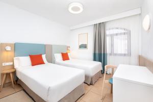 a hotel room with two beds and a window at HD Parque Cristobal Tenerife in Playa de las Americas