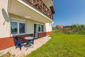 a patio with two chairs and a table on the side of a house at Niska, Sun & Snow in Krynica Morska