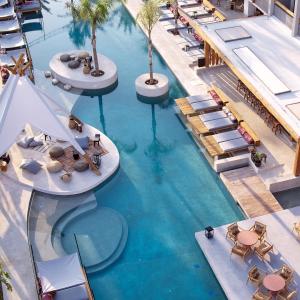 una vista aérea de una piscina con sillas y palmeras en The Syntopia Hotel - Adults Only en Adelianos Kampos