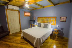 a bedroom with a bed and a blue wall at Hotel Hacienda Don Paolo in San Vito