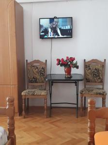 a room with two chairs and a table with a tv on the wall at Apartments and Rooms Juki in Senj