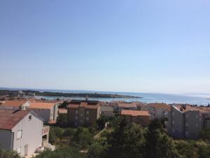 a city with buildings and the ocean in the background at Apartments MiaMaja in Novalja