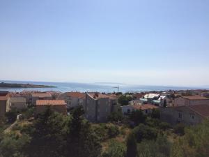a city with houses and the ocean in the background at Apartments MiaMaja in Novalja