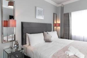 
a hotel room with a large bed and a large mirror at The House Hotel, an Ascend Hotel Collection Member in Galway
