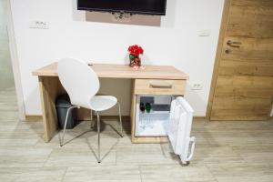 a desk with a white chair and a small refrigerator at Guesthouse Urša in Preddvor +53 photos