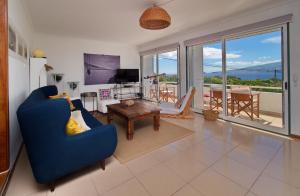 a living room with a blue couch and a table at epicenter PICO in Madalena