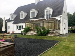 een wit huis met een serre in de tuin bij Maison Blanche in Wielsbeke