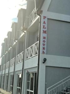 a building with a hotel sign on the side of it at Palm Hotel in Novy Afon