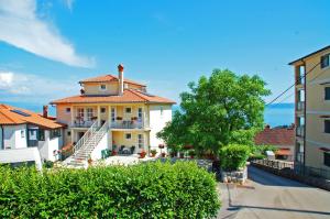 een groot wit huis met een trap ervoor bij Apartments Kolmanic, sea view, free privat parking in Ičići