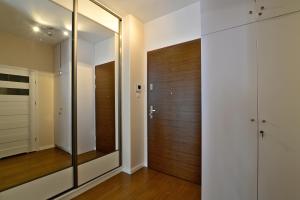 korytarz z drewnianymi drzwiami i lustrem w obiekcie 14-nastka Nowe Orłowo Gdynia w mieście Gdynia