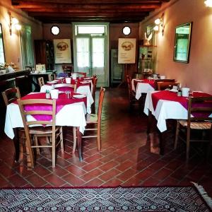 restauracja z czerwono-białymi stołami i krzesłami w obiekcie Bordeghina B&B In Farmhouse w mieście Pontecchio Polesine