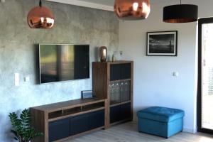 a living room with a tv and a blue stool at Regatowa Przystań in Mechelinki