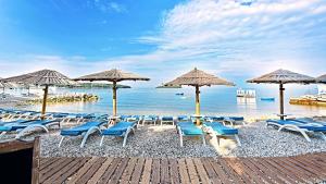 a bunch of chairs and umbrellas on a beach at Apartments Mediteraneo in Vrsar