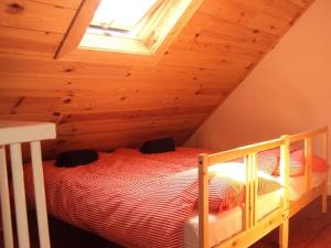 ein Schlafzimmer mit einem Bett im Dachgeschoss mit einem Fenster in der Unterkunft Boerderij De Vrije Geest in Toldijk