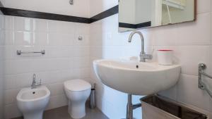 een witte badkamer met een wastafel en een toilet bij Italianway - Sant'Oronzo Apartment in Lecce +21 foto's