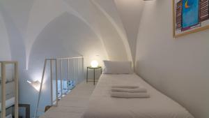 een witte kamer met een bed en een trap bij Italianway - Sant'Oronzo Apartment in Lecce