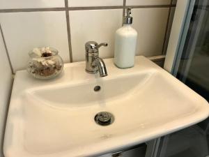- un lavabo dans la salle de bains avec un distributeur de savon dans l'établissement Kungsgatans Gryta & Hotell, à Malmö