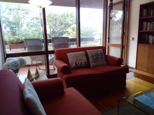 Un Balcon Sur La Mer في فونشال: غرفة معيشة مع أريكة حمراء ونافذة