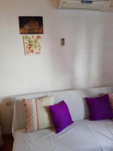 a white couch with purple pillows in a room at Apartment Josip -Tomic in Miletići