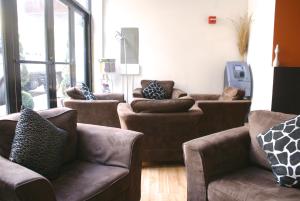 una sala de estar con sofás, mesas y ventanas en Off SoHo Suites Hotel en Nueva York