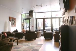 ein Wohnzimmer mit Sofas, Sesseln und Fenstern in der Unterkunft Off SoHo Suites Hotel in New York