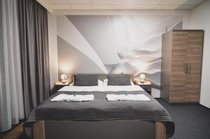 a bedroom with a large bed with two pillows at Penzion Pod Radnicí in Hustopeče