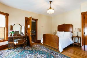 Schlafzimmer mit einem Bett, einem Tisch und einem Spiegel in der Unterkunft Reynolds House Inn in Barre