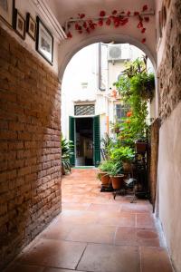 un arco in un edificio di mattoni con piante in vaso di Il nido - Cozy studio apartment in Santa Croce a Firenze