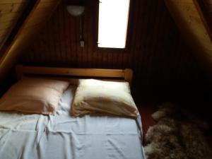 een slaapkamer met een bed met twee kussens en een raam bij Chata Jedľoviny Martin in Martin