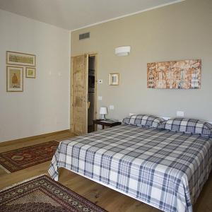 ein Schlafzimmer mit einem Bett mit einer blauen und weißen Decke in der Unterkunft Ca' del Cuco in Barzana