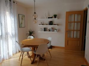 a dining room with a wooden table and white chairs at Apartamento Serreria de Boltaña in Boltaña