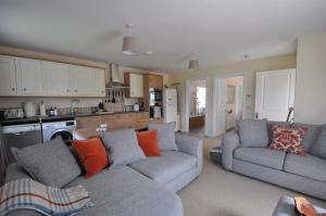 a living room with two couches and a kitchen at No 1 Ramageton at Carnell Estates in Hurlford +26 photos