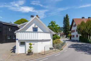 Ein weißes Haus an der Seite einer Straße in der Unterkunft Ferienhaus Bachschlössle in Lochau