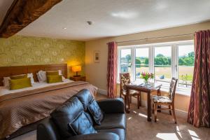 - une chambre avec un lit, un bureau et une fenêtre dans l'établissement The Stratford Park Hotel & Golf Club, à Stratford-upon-Avon