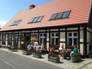 a group of people sitting outside of a building at Dom Wakacyjny Mistral in Ustka
