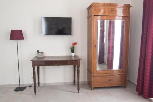 a room with a dresser and a mirror and a table at Papiroom's in Siracusa
