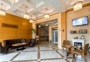 a lobby with a fireplace and a tv on the wall at Sacvoyage Hotel in Almaty