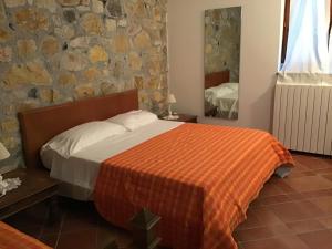 a bedroom with a bed and a mirror at casa Anna De Croy in Magliano in Toscana