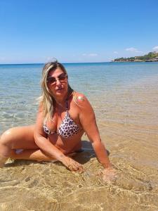 een vrouw ligt in het water op het strand bij Resort ' Njulella in Migliarello