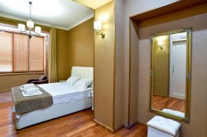 um pequeno quarto com uma cama e um espelho em Exclusive Apartament the Heart of Old Kutaisi em Kutaisi